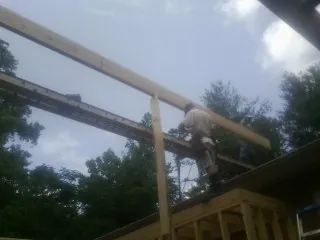 Carpenter setting a ridge beam over a new addition frame — Ice Dam Removal by Roofing Brothers in Danvers