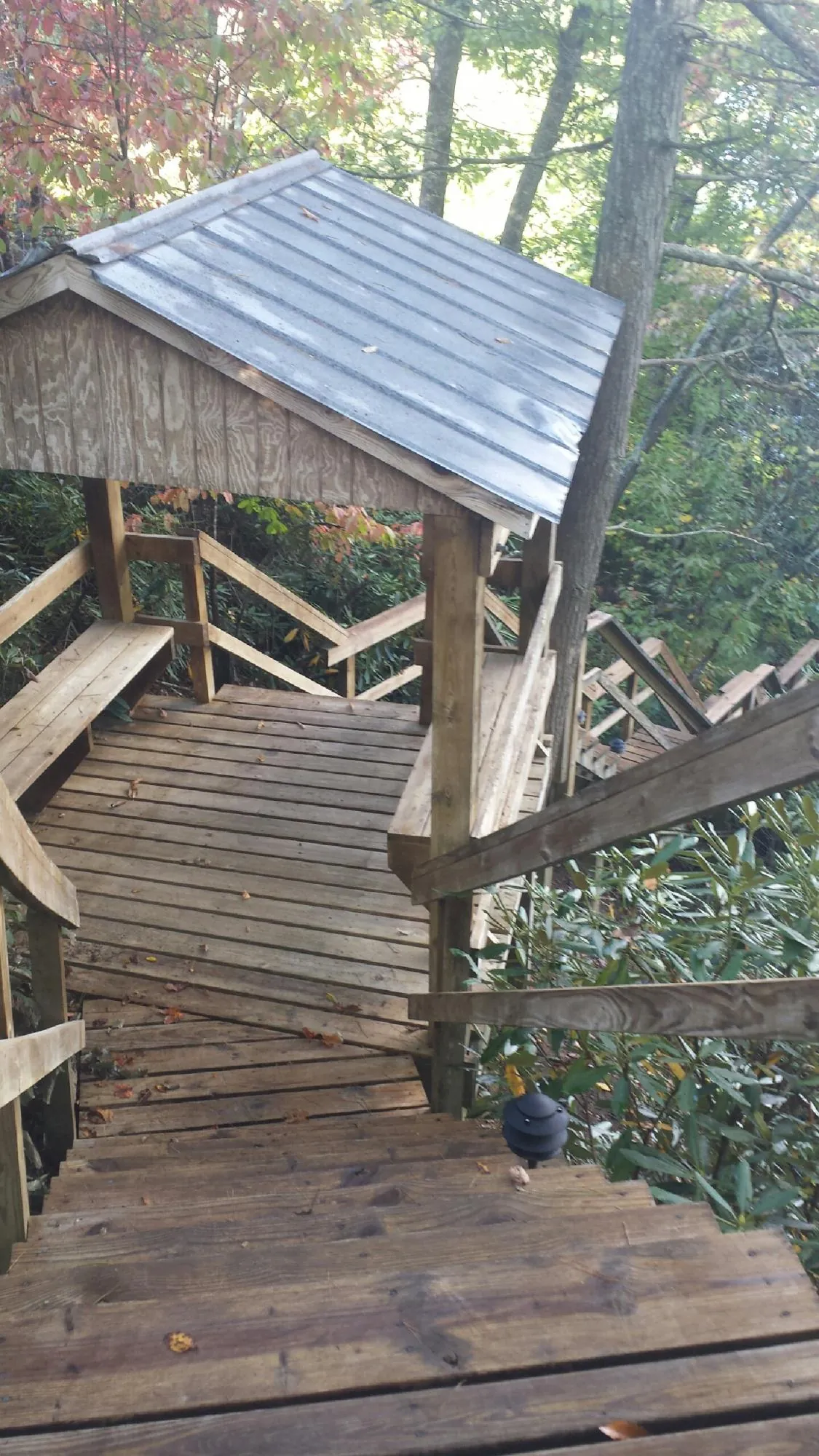 Metal roofed shelter over wooden steps on a wooded walkway — Skylight Repair & Installation work by our crew in Danvers