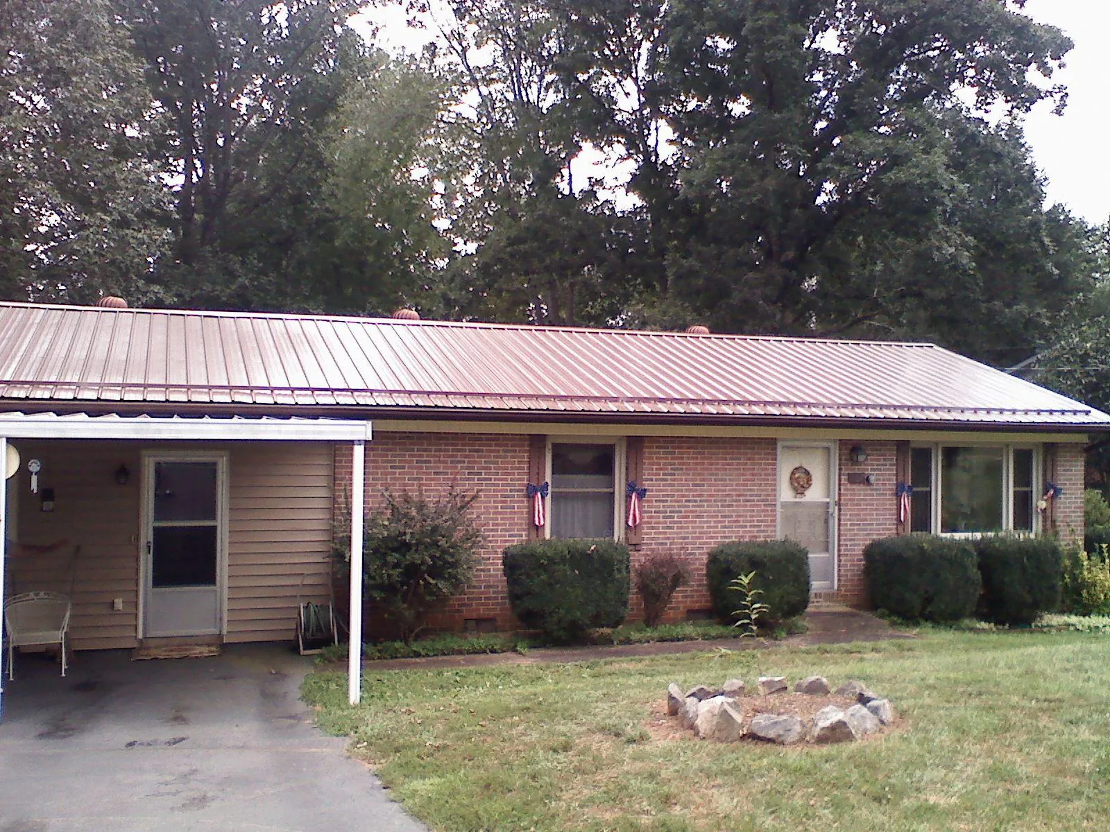 Bronze metal roof and carport on a brick ranch home — Roof Repair work by our crew in Danvers